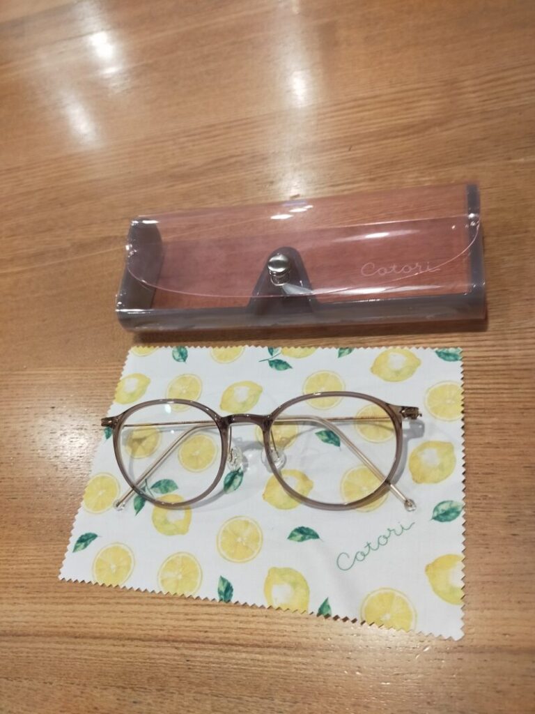 子供用メガネとレモン柄の眼鏡拭き、クリアなピンクの眼鏡ケースの写真