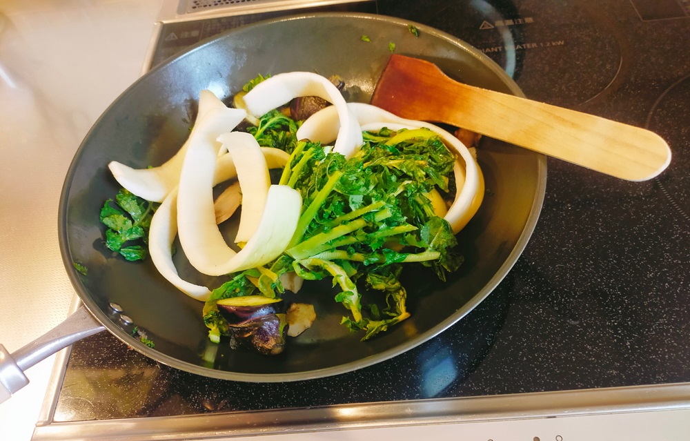 鉄製フライパンをIH調理器の上で野菜くずを炒めている様子