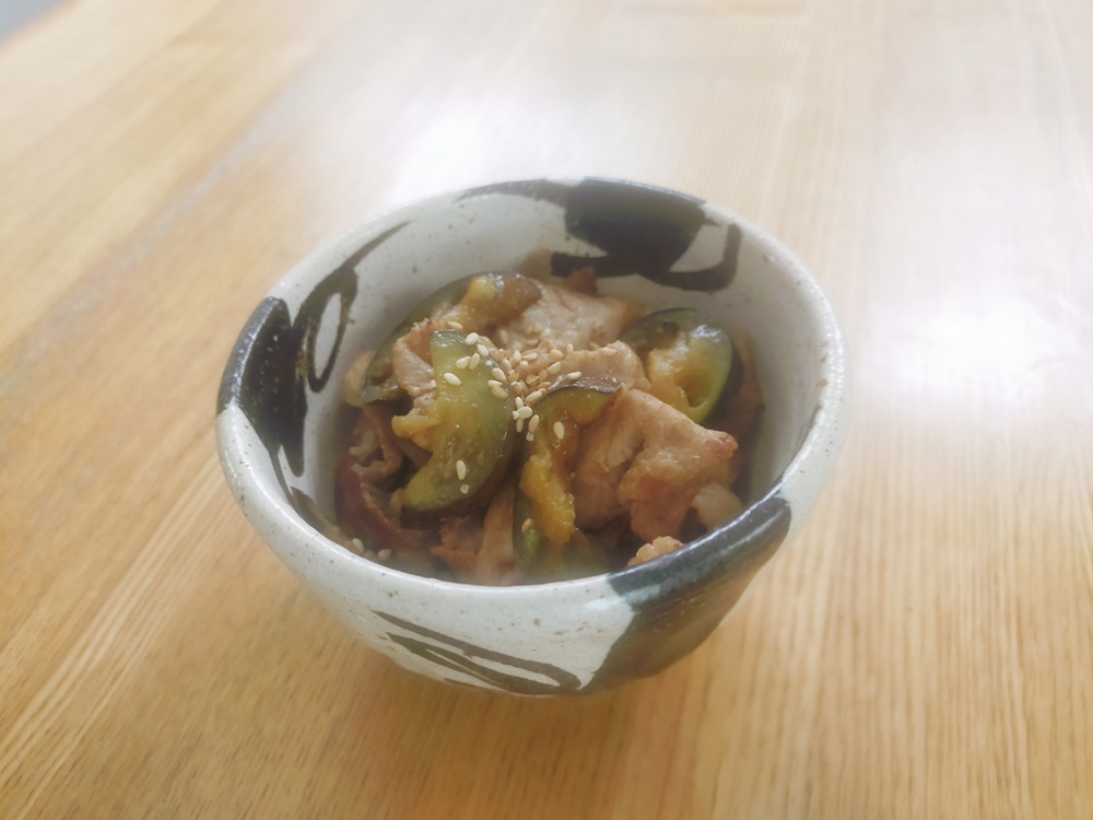 家庭菜園で採れたナスと豚肉の炒め物が和小鉢に盛り付けられた写真
